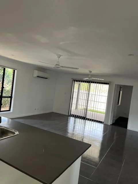 Unfurnished tiled living and kitchen area after cleaning